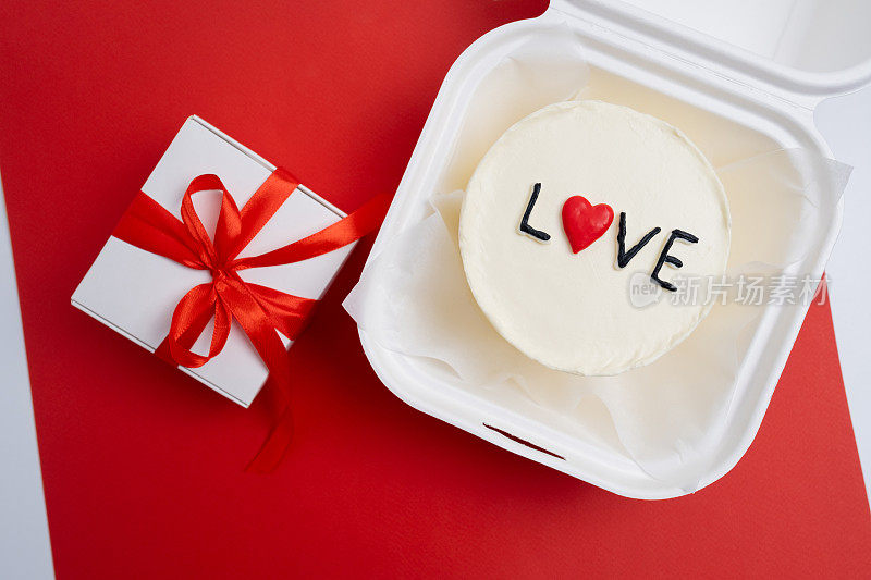 便当蛋糕上写着"爱与心"一个可爱的甜点礼物，适合任何场合给你爱的人。祝贺卡。爱情与糖果概念